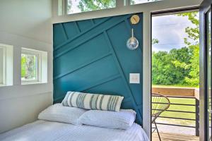 Bett mit blauem Kopfteil in einem Schlafzimmer in der Unterkunft Modern Starkville Tiny Home Near Dining and MSU in Starkville