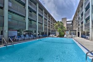 a swimming pool in the courtyard of a building at Ocean-View Resort Condo with Pool and Beach Access in Fernandina Beach