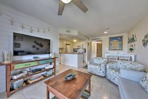 sala de estar con TV, sofá y mesa en Ocean-View Resort Condo with Pool and Beach Access en Fernandina Beach