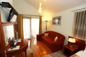 ein Wohnzimmer mit einem roten Sofa und einem Tisch in der Unterkunft Villa Ivana B&B in Zadar