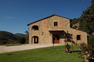 a large stone building with a grass yard at Tenuta Poggio Marino in Dicomano