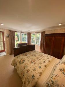 a bedroom with a bed with a floral bedspread at Twin Totara Cottage in Upper Hutt