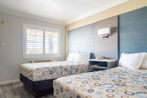 a hotel room with two beds and a window at Solaire Inn & Suites in Santa Maria