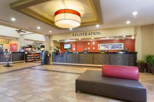a lobby of a fast food restaurant with a red chair at Rosen Inn Lake Buena Vista in Orlando