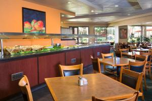 a restaurant with wooden tables and chairs and a bar at Rosen Inn Lake Buena Vista in Orlando