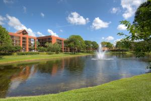 a pond in front of a building with a fountain at Rosen Inn Lake Buena Vista in Orlando