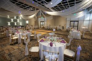 a banquet hall with white tables and chairs at Rosen Inn Lake Buena Vista in Orlando +37 photos