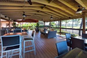 a covered deck with tables and chairs on a porch at Rosen Inn Lake Buena Vista in Orlando