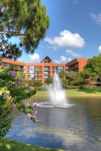 a fountain in the middle of a pond in front of a building at Rosen Inn Lake Buena Vista in Orlando