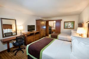 a hotel room with two beds and a desk at Rosen Inn Lake Buena Vista in Orlando