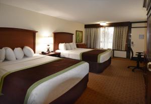 a hotel room with two beds and a window at Rosen Inn Lake Buena Vista in Orlando