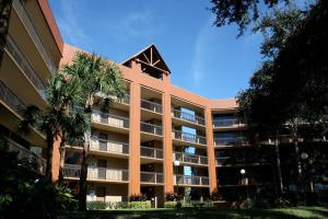 a large building with palm trees in front of it at Rosen Inn Lake Buena Vista in Orlando