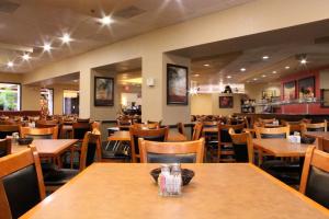 a dining room with wooden tables and chairs at Rosen Inn Lake Buena Vista in Orlando