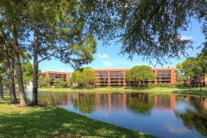 an office building with a lake in front of it at Rosen Inn Lake Buena Vista in Orlando