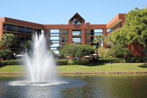 a fountain in the middle of a pond in front of a building at Rosen Inn Lake Buena Vista in Orlando