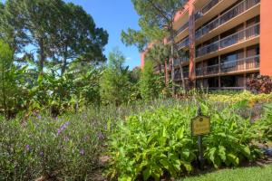a garden with purple flowers in front of a building at Rosen Inn Lake Buena Vista in Orlando