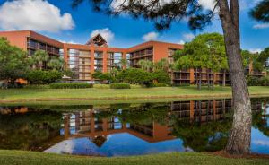 an office building with a reflection in the water at Rosen Inn Lake Buena Vista in Orlando