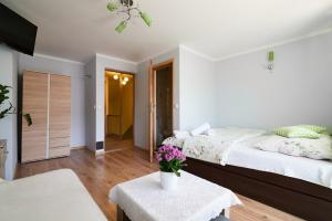 een slaapkamer met een bed en een tafel met bloemen erop bij Willa u Perełki in Zakopane