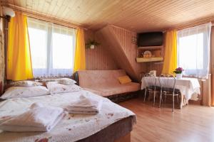 een slaapkamer met 2 bedden en een tafel en stoelen bij Willa u Perełki in Zakopane