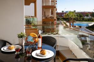 een tafel met glazen wijn en eten op een balkon bij Terraços do Rio in Portimão
