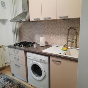 een keuken met een wasmachine en een wastafel bij SUNRISE in Boekarest