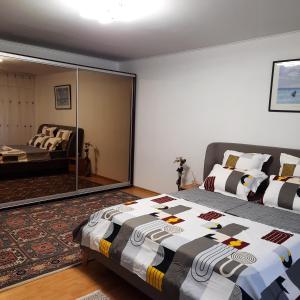 een slaapkamer met een bed en een spiegel bij SUNRISE in Boekarest