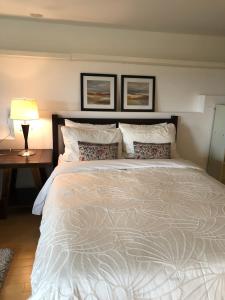 Un dormitorio con una cama grande y una mesa con una lámpara. en one bedroom suite near Hillside mall, en Victoria