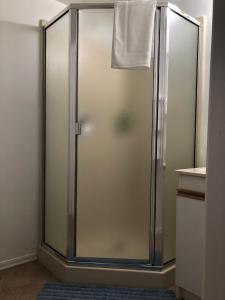 um chuveiro com uma porta de vidro na casa de banho em one bedroom suite near Hillside mall em Victoria