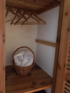 a basket of towels on a shelf in a room at Adega do Golfinho in Feiteira