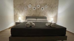 1 dormitorio con 1 cama con 2 pares de zapatillas en Testa di Moro, en Marsala