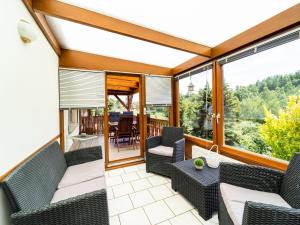 a screened in porch with chairs and a table at Detached Bungalow in G ntersberge in the Harz Mountains in Harzgerode