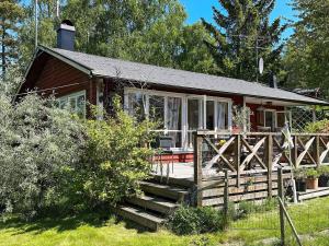 een klein huis met een veranda en een trap. bij Holiday home ORNÖ in Ornö