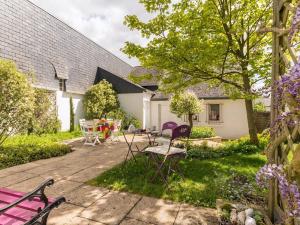 eine Terrasse mit Stühlen und Tischen im Hof in der Unterkunft Gîte Blain, 2 pièces, 2 personnes - FR-1-306-1007 in Blain