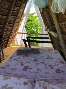 łóżko w pokoju z oknem w obiekcie JARDIM ENCANTADO ECOHOSPEDARIA w mieście Camaçari