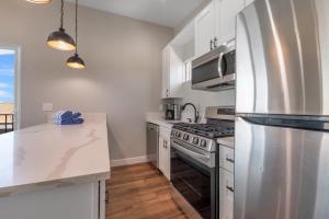 eine Küche mit weißen Schränken und einem Kühlschrank aus Edelstahl in der Unterkunft Mission Bay Vista in San Diego
