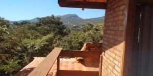 een balkon van een huis met uitzicht op de bergen bij Chalé 2 Recanto Shambala - a 2,5 km de São Thomé in São Thomé das Letras