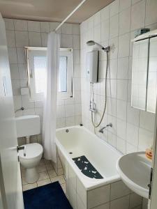 a bathroom with a tub and a toilet and a sink at Bei Daniel am Dortmunder Flughafen in Dortmund