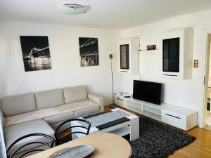 uma sala de estar com um sofá e uma televisão em Bei Daniel am Dortmunder Flughafen em Dortmund