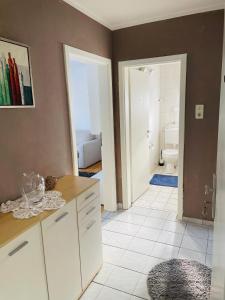 a kitchen with white cabinets and a bathroom with a toilet at Bei Daniel am Dortmunder Flughafen in Dortmund