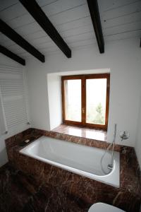 a bath tub in a room with a window at B&B Castel Ivano in Strigno