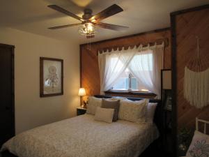 een slaapkamer met een bed met een plafondventilator bij Lazy Pines in Sugarloaf