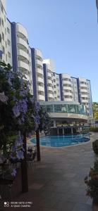 a large apartment building with flowers in front of it at Apart no Águas da Serra - 115B in Rio Quente