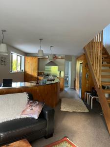a living room with a couch and a kitchen at Kahu Farm Apartment in Matakana