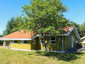 una casa amarilla y verde con un árbol en el patio en Holiday home Hadsund CXXX en Hadsund