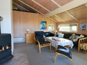 sala de estar con sofá, mesa y chimenea en Holiday home Hadsund CXXX en Hadsund