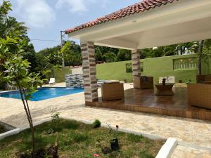 a patio with furniture and a swimming pool at Villa La Esperanza in Nizao