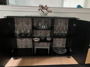 a black shelf with glasses and a vase on it at Cheerful beautiful cottage 3 bedroon in Wasaga Beach