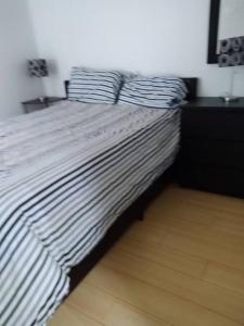 a bed with black and white striped sheets on it at Cheerful beautiful cottage 3 bedroon in Wasaga Beach
