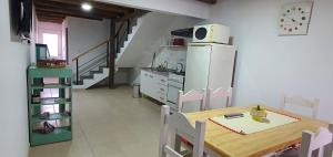a kitchen with a wooden table and a refrigerator at LOS CACTUS in Malargüe