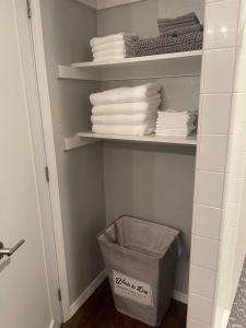 a bathroom with a shelf with towels and a basket at OU-2 bed 2 bath apartment close to OU in Oklahoma City